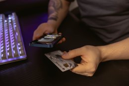 Банковская карта и телефон в руках для осуществления перевода