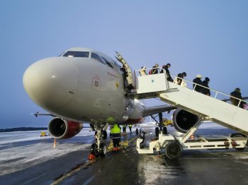 Пассажиры выходят из самолёта.