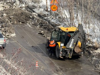 Трактор убирает снег весной