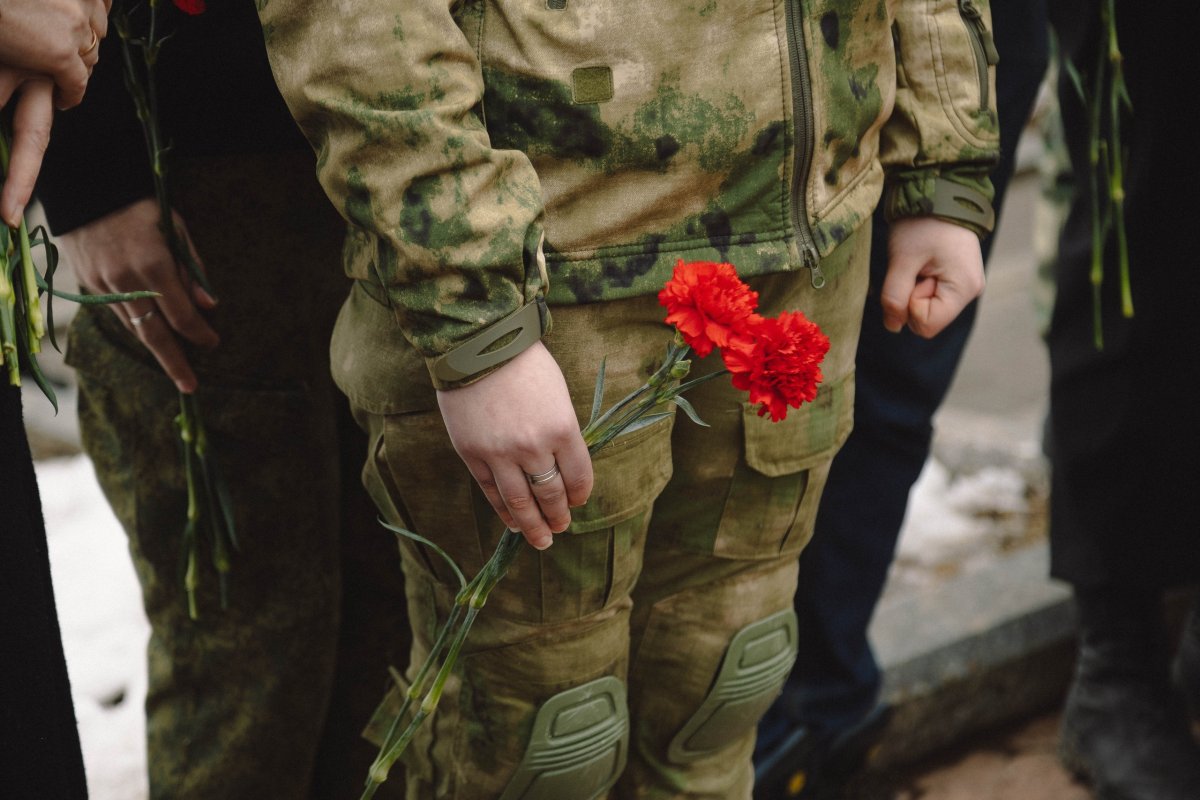 Молодой человек в камуфляже и с гвоздикой