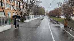 Человек с зонтом идёт под дождём