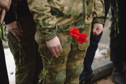 Молодой человек в камуфляже и с гвоздикой