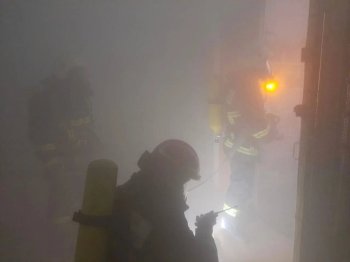 Пожарные идут через дым в здании