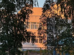 Здание в листве деревьев.