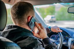 мужчина разговаривает по телефону за рулём автомобиля