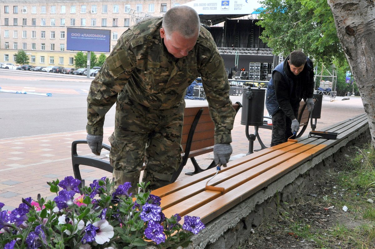 Военнослужащий красит лавку