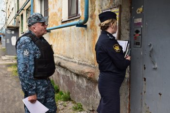 Судебный пристав заходит в подъезд дома