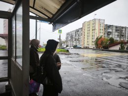 Люди на остановке в дождь