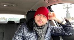 Задумчивый мужчина в красной шапке сидит в машине