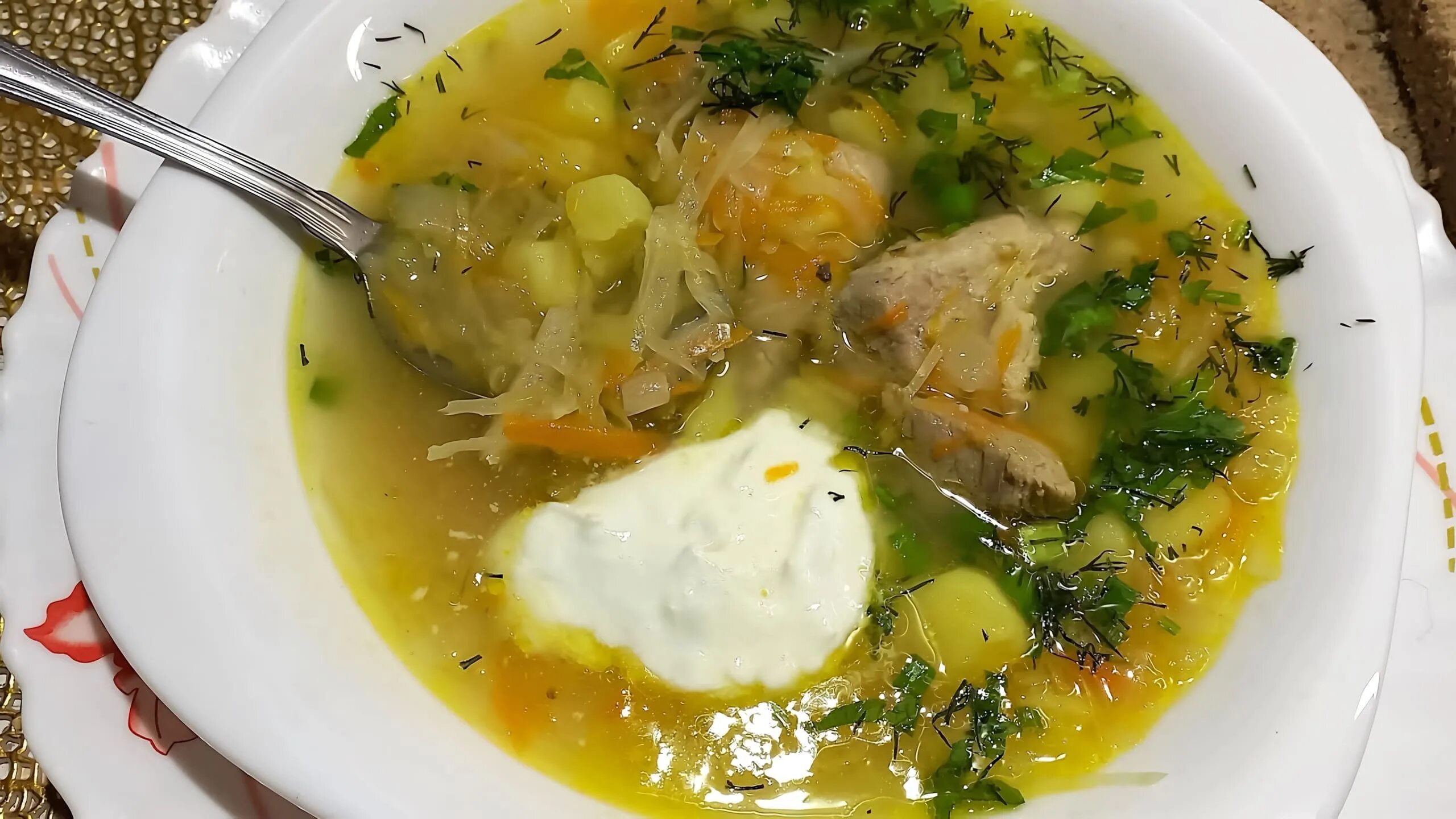 Тарелка щей на столе.